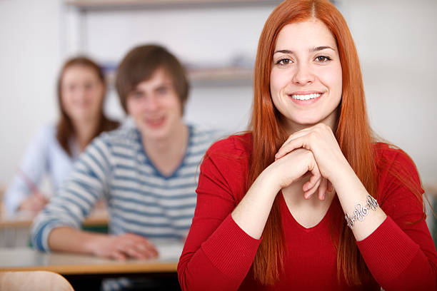 istock Female student smiling in front of classroom 185069043