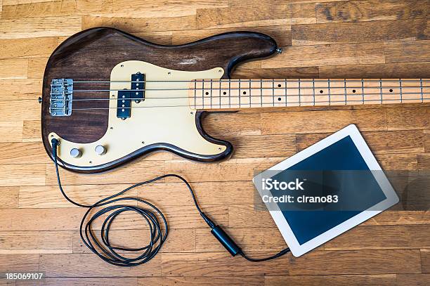 Bass Guitar On Wooden Table Attached To Digital Tablet Stock Photo - Download Image Now