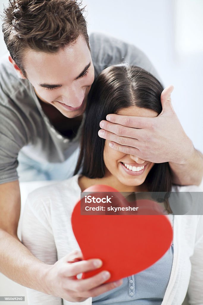 Surprise Man surprising woman with gift for Valentine's day. Adult Stock Photo