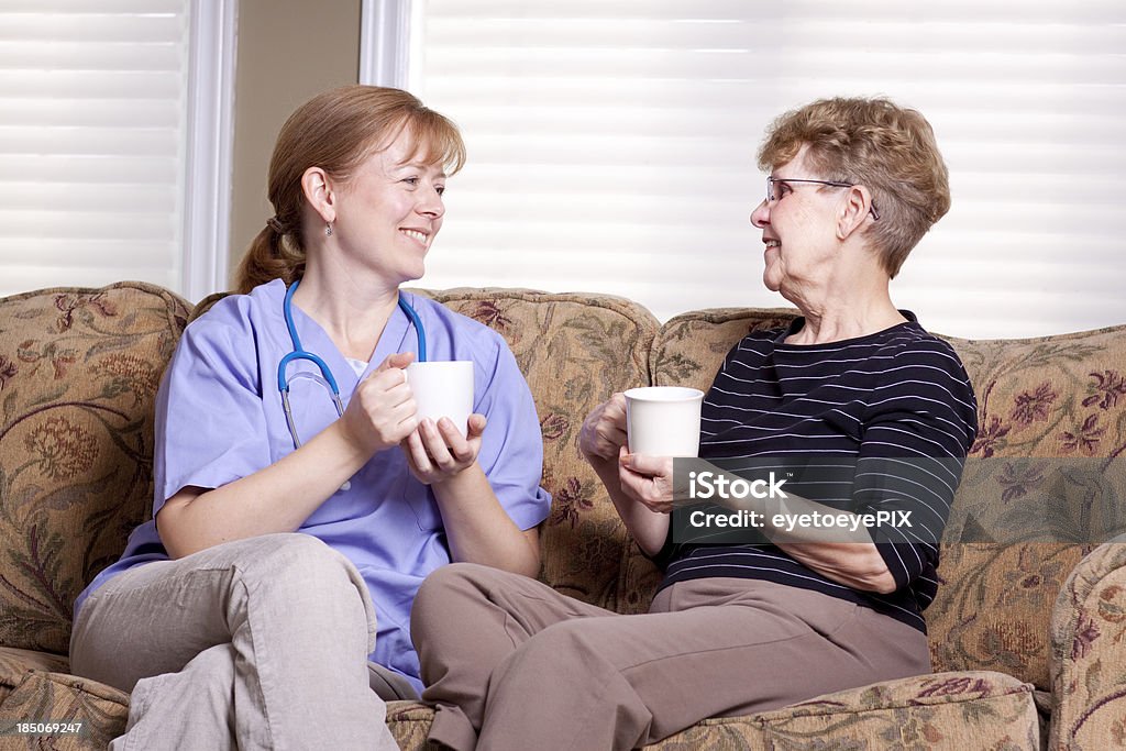 高齢者の介護人女性とソファー、コーヒー - 2人のロイヤリティフリーストックフォト
