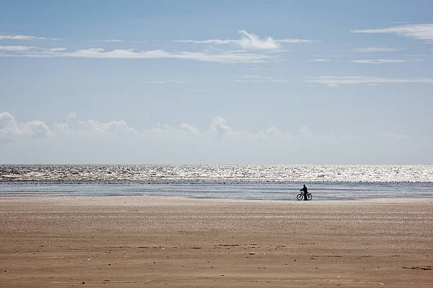 istock Cyclist in silhouette on the beach 185069362