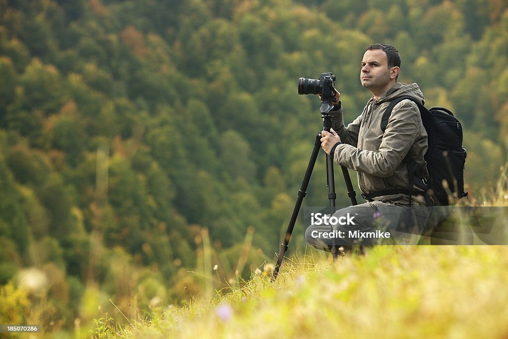 Landscape photographer in action Landscape photographer shooting autumn scenes high in the mountains Adult Stock Photo