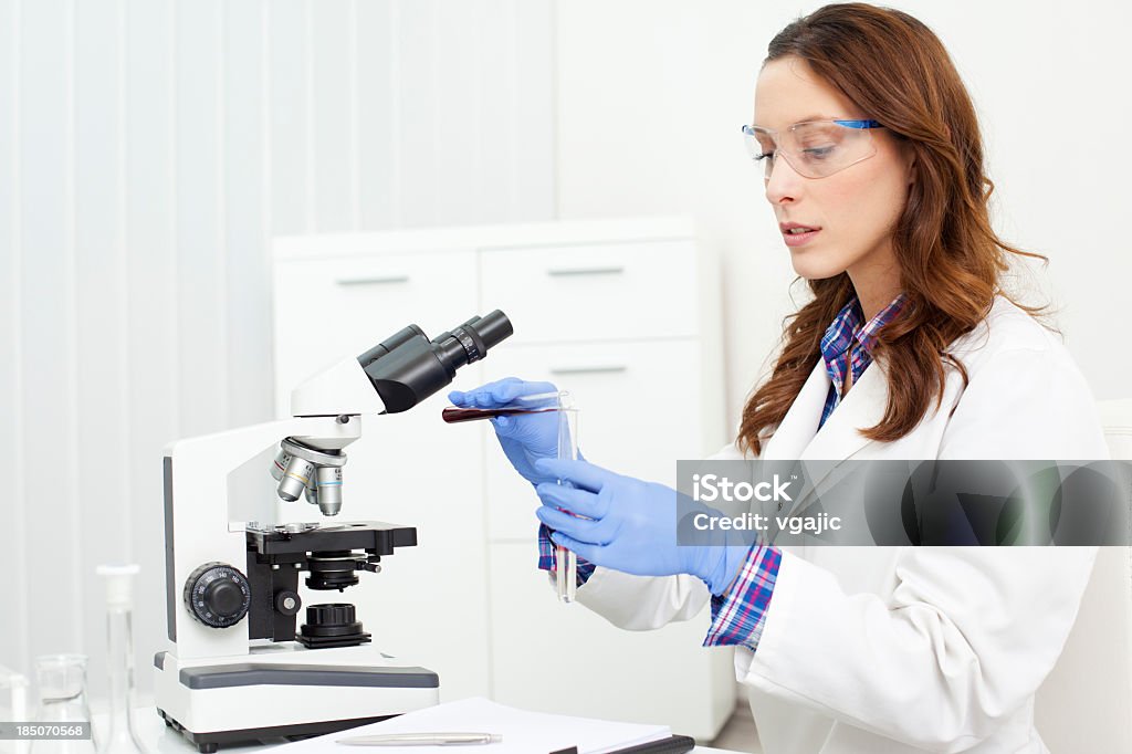 Female Scientist Looking Through a microscope Female Scientist Doctor Looking Through a microscope Looking Through An Object Stock Photo