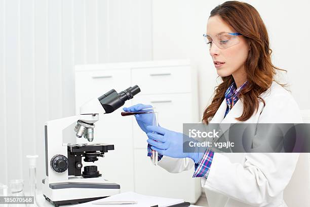 Female Scientist Looking Through A Microscope Stock Photo - Download Image Now - Looking Through An Object, Microscope, Scientist