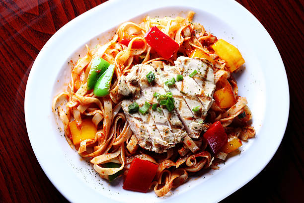 Cajun Pasta with Grilled Chicken Breasts and Seasoning "Cajun Pasta with succulent grilled chicken breasts, diced tomatoes, onions, peppers and Seasoning" cajun food photos stock pictures, royalty-free photos & images