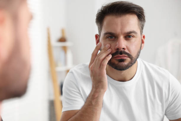 istock Confused man with skin problem looking at mirror indoors 1850708195