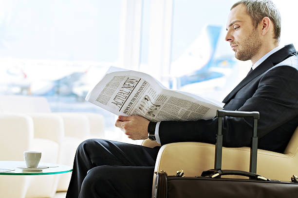 Waiting man Businessman reading newspaper while waiting for the flight newspaper airport reading business person stock pictures, royalty-free photos & images