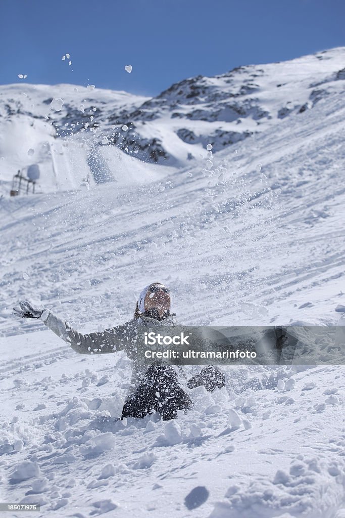 Female skier playing with snow outdoor "Happy  woman throwing snow in the air and relaxing in sunshine during skiing break on ski vacation. High mountain landscape. Ski resort in the snowy Les 2 Alpes - France . Les Deux Alpes is a high altitude resort with a glacier peaking at 3,600m.SEE ALSO:" Adult Stock Photo
