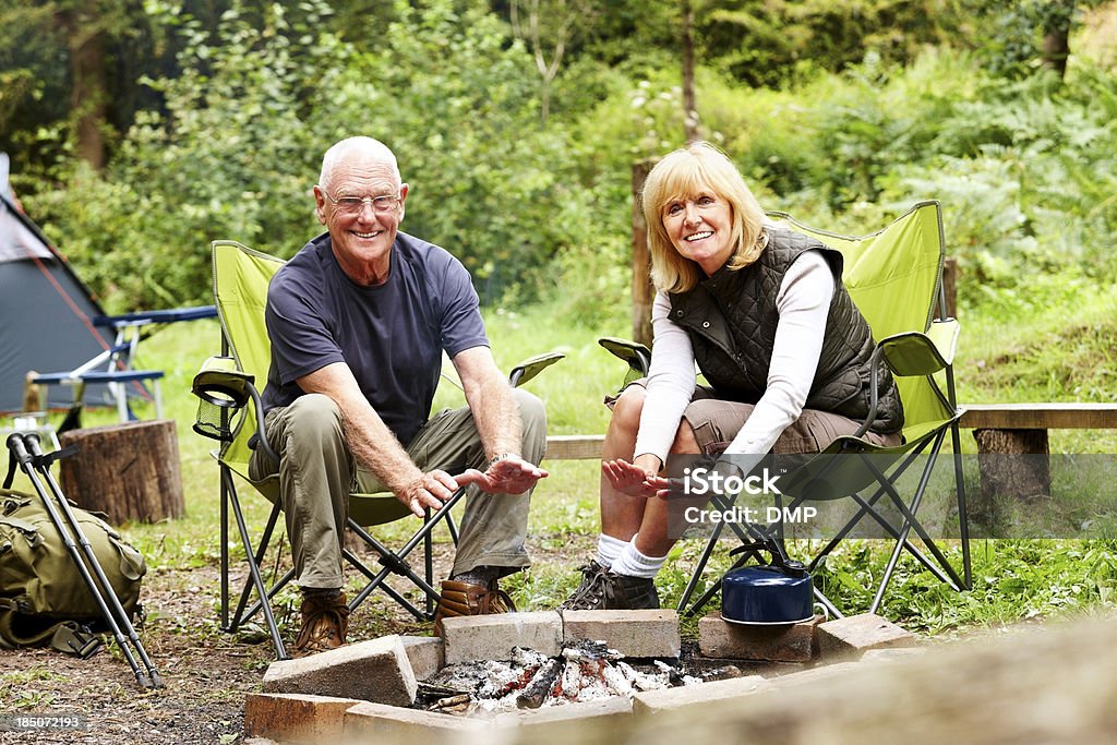 Belo Casal de idosos prejudicar as mãos na Fogueira de acampamento - Royalty-free Acampar Foto de stock