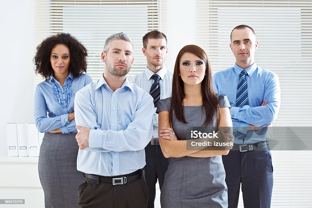 Business Team Portrait of five serious business people standing in two rows in an office. Five People Stock Photo