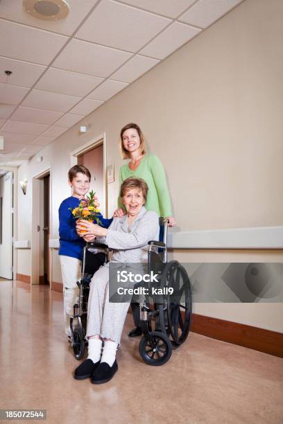 Famiglia Donna Anziana In Visita In Ospedale - Fotografie stock e altre immagini di 8-9 anni - 8-9 anni, 80-89 anni, Accudire