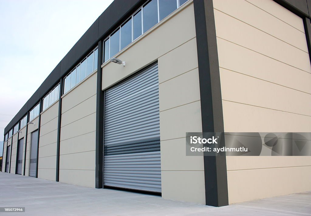 A wooden warehouse building lit up by the sun Warehouse building. Rolling Garage Door Stock Photo