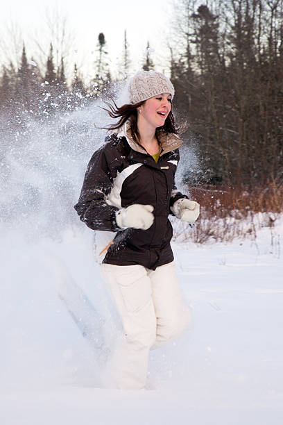 femme cours'en raquettes dans la poudreuse - winter snowshoeing running snowshoe photos et images de collection