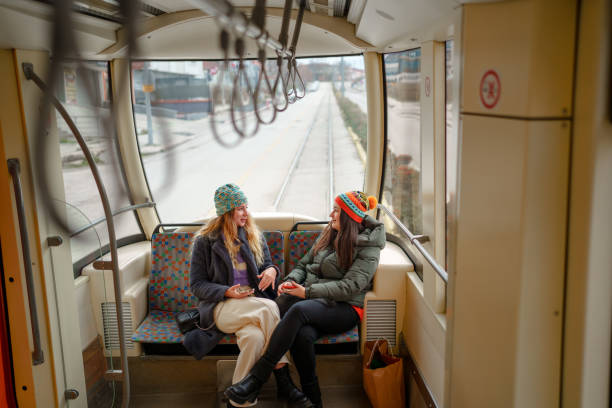 istock Female friends sitting and talking in tramway. 1850735544