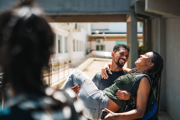 istock Young man holding his girlfriend on his lap on campus 1850738111