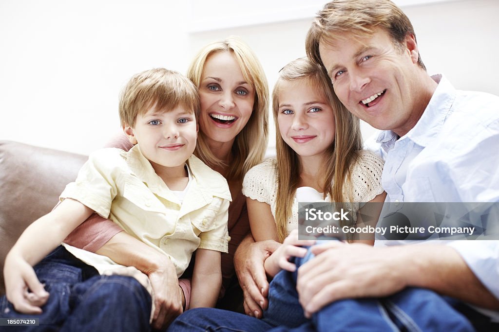 Strong genes Attractive young family smiling while relaxed at home Adult Stock Photo