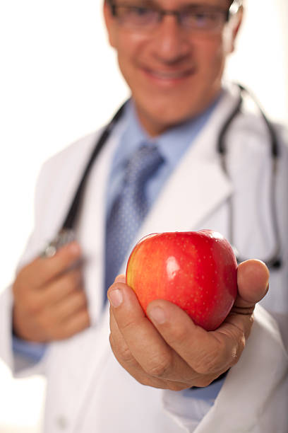 Doctor Handing you an Apple stock photo