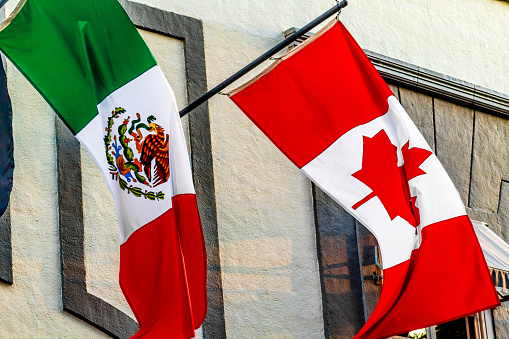 Banderas de México y canada ondeando en un edificio