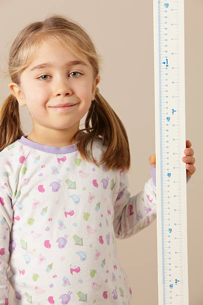 istock 5 year old girl measuring height 185075424