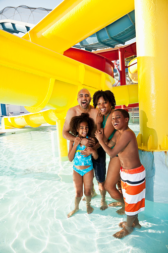 Family with children, 8 and 12 years, by water slide.