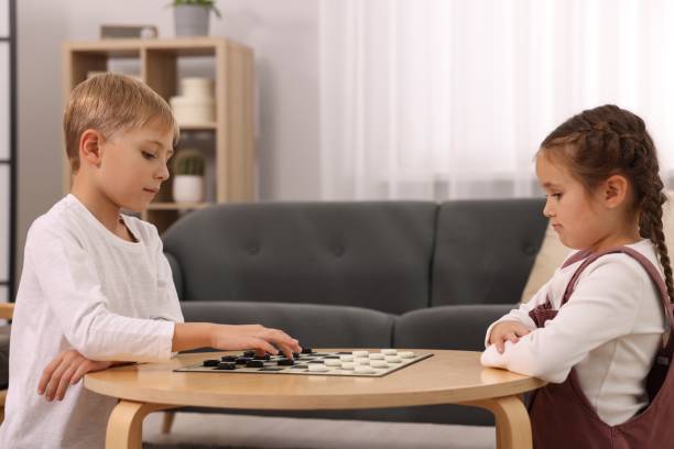 istock Children playing checkers at coffee table in room 1850761847