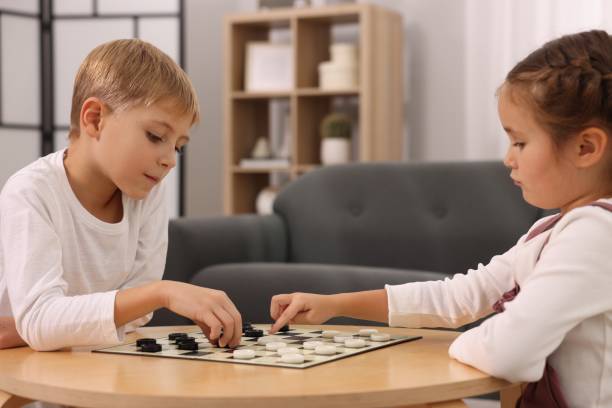istock Children playing checkers at coffee table in room 1850762884