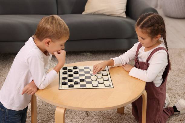 istock Children playing checkers at coffee table indoors 1850762886