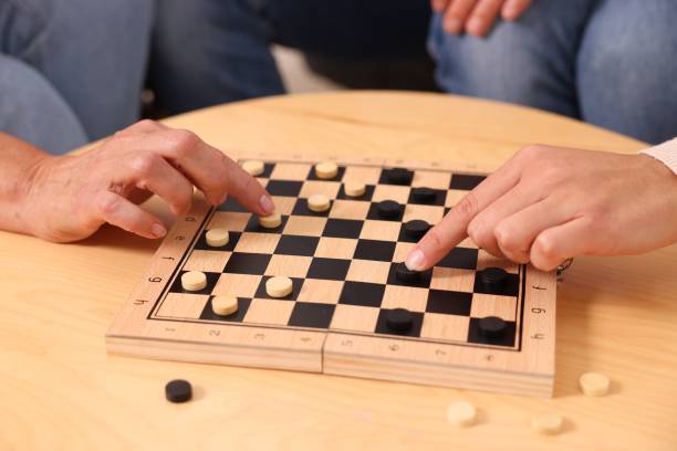 istock People playing checkers at wooden table, closeup 1850766063