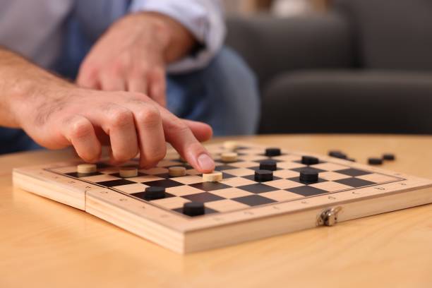 istock Man playing checkers at wooden table, closeup 1850768681