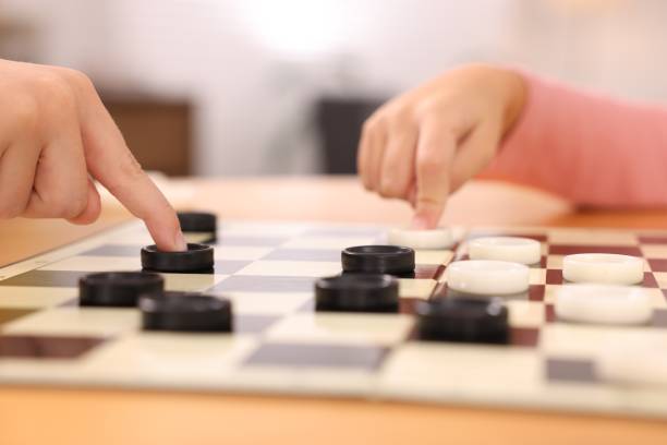 istock Children playing checkers at table indoors, closeup 1850769188