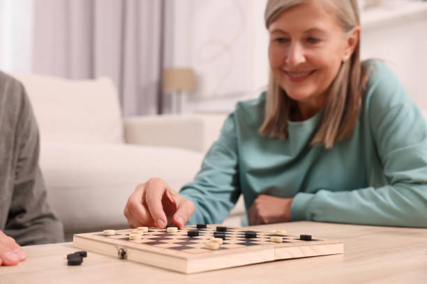 istock People playing checkers at wooden table in room, selective focus 1850769200