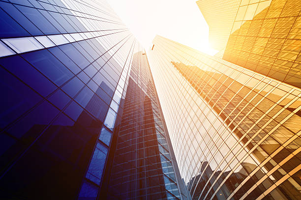 Looking up at tall buildings with sun shining down
