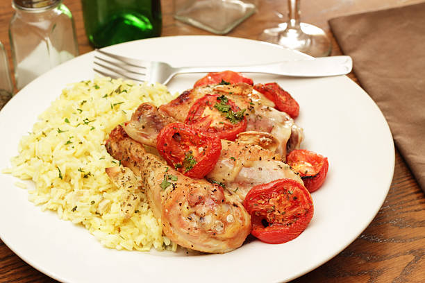 Roast Chicken and Tomatoes "A rustic dish of roasted chicken, tomatoes and whole garlic with herbs.Served with a side of herbed ricePlease see some similar pictures from my portfolio:" drumstick stock pictures, royalty-free photos & images