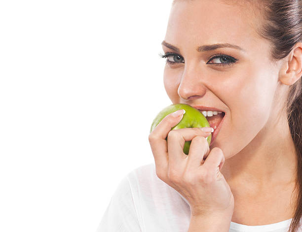 istock young smiling girl eats a green apple 185078066
