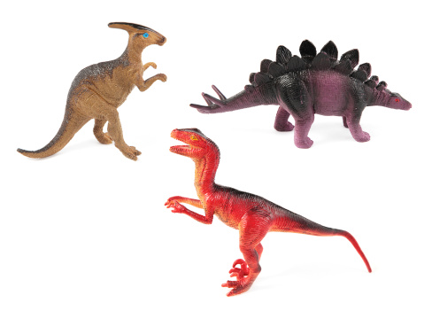 Three plastic toy dinosaurs on white