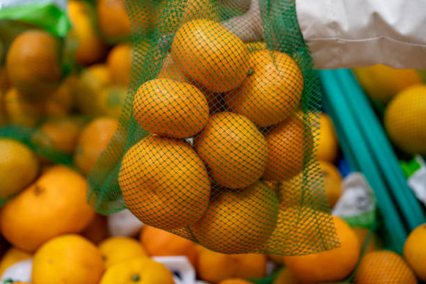 istock woman buying oranges 1850789488