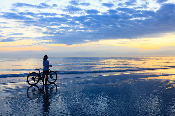 istock Woman with bicycle at beach 185078965