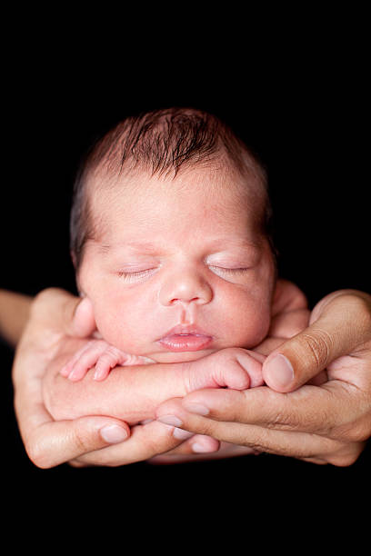 istock Color Image of Peaceful Newborn Sleeping in Father's Hands 185079213