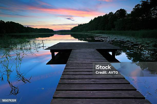 Wooden Boardwalk Dock On Remote Lake Amongst Forest At Sunset Stock Photo - Download Image Now