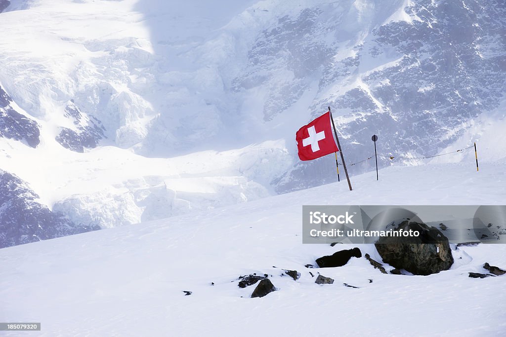 Switzerland flagg in swiss alps Swiss flag in the wind on a background of beautiful mountainSEE ALSO: Mountain Stock Photo