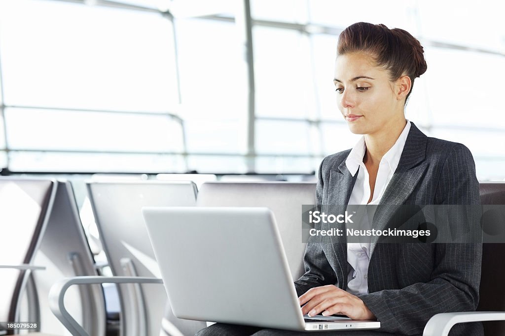 Mujer trabajando en una computadora portátil en el aeropuerto - Foto de stock de Adulto libre de derechos