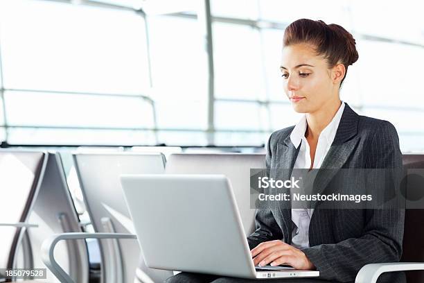 Mujer Trabajando En Una Computadora Portátil En El Aeropuerto Foto de stock y más banco de imágenes de Adulto