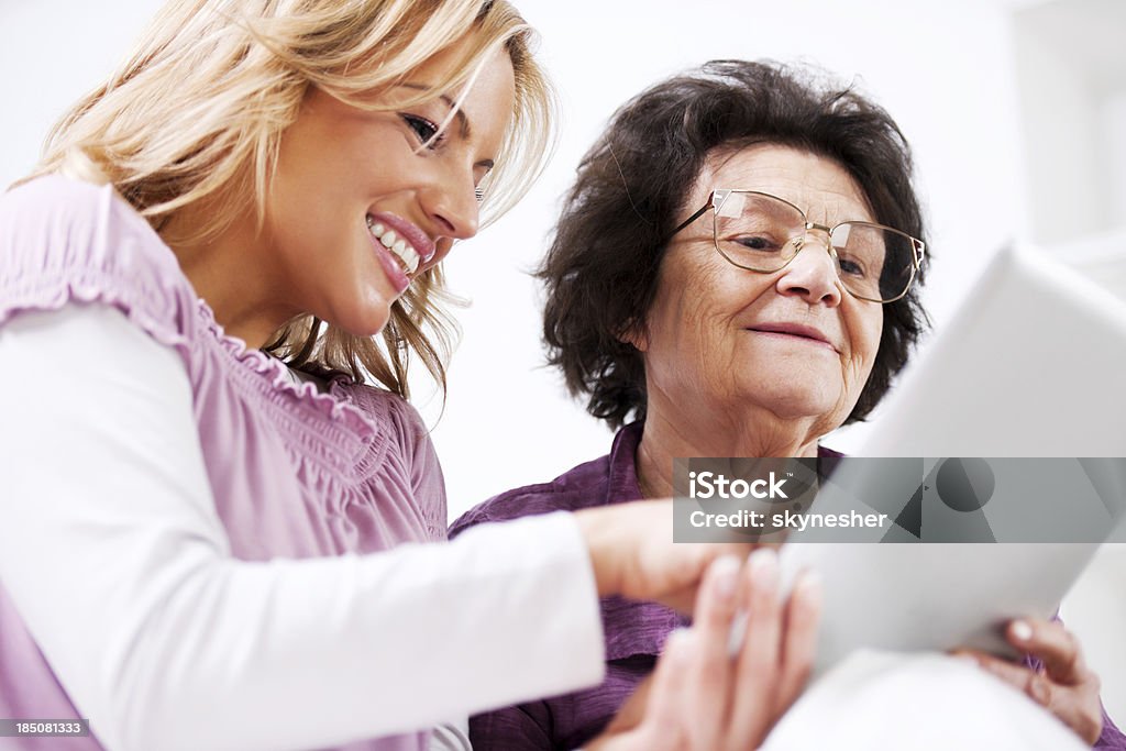 senior mère apprenant à sa fille à utiliser Souris tactile - Photo de Enseigner libre de droits