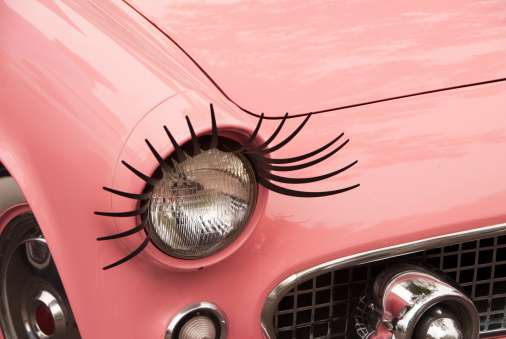 Eyelashes on a headlight on a pink retro car