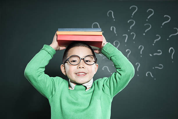 istock one boy stands in front of the blackboard 185081520
