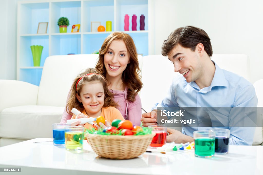 Family Coloring Easter Eggs Family, mother, father and daughter Enjoy Coloring Easter Eggs at home. Mother laughing and looking at camera. 30-39 Years Stock Photo