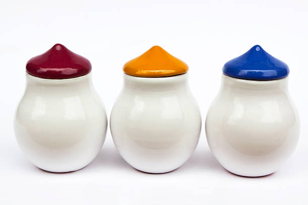 istock Three white ceramic spices jars with red, yellow, blue lids 185083086
