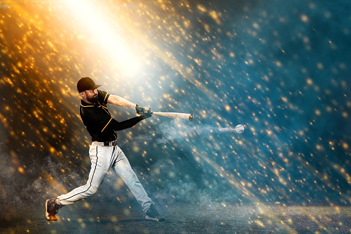 Porfessional baseball player with bat taking a swing on grand arena. Ballplayer on stadium in action