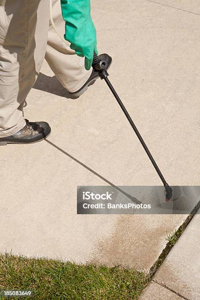 Lawn Care Arbeiter Sprühen Stray Gras Riss In Auffahrt Stockfoto und mehr Bilder von Jäten