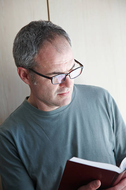 istock Mature caucasian man reading book indoors 185084055